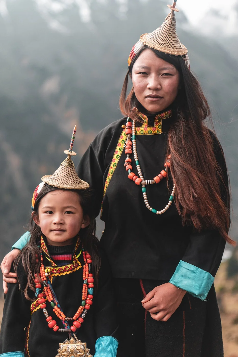 A woman and child from Laya wearing distinctive highland dress and traditional conical hats