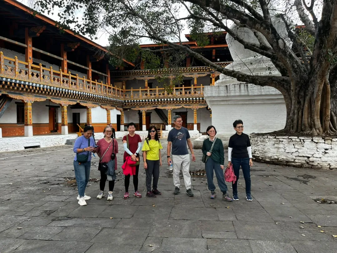 A group of Singaporean travellers in a Bhutanese monastic courtyard